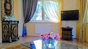 a living room with a glass table with a vase of flowers at Fantasy in Karlovy Vary