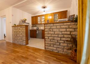 a living room with a brick wall and a kitchen at Apartman Rita in Bjelovar