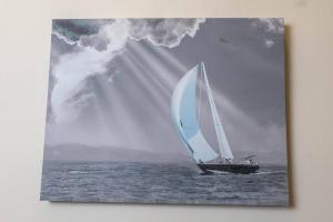 a sailboat in the ocean with a ray of sunlight at Hoboken Haven – Heart of town! in Hoboken
