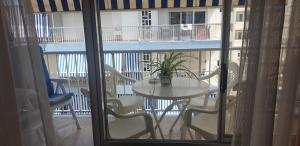 een tafel met stoelen en een plant op een balkon bij Apartamento Turístico en Playa de Gandía in Playa de Gandia