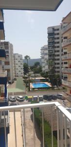 uitzicht op een zwembad vanaf het balkon van een gebouw bij Apartamento Turístico en Playa de Gandía in Playa de Gandia