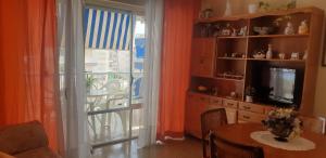 een woonkamer met een eettafel en een glazen schuifdeur bij Apartamento Turístico en Playa de Gandía in Playa de Gandia