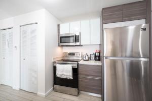 a kitchen with a stainless steel refrigerator and a microwave at Subtle 2 Bed in Edgewater Downtown with Free Parking in Miami