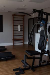 a gym with a treadmill and a chair in a room at Comfort Hotel Presidente Prudente in Presidente Prudente