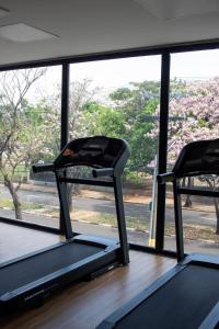 a room with two treadmills in front of a window at Comfort Hotel Presidente Prudente in Presidente Prudente