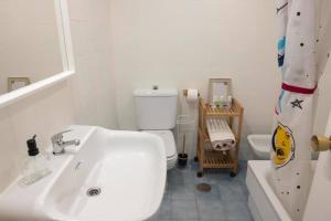 a white bathroom with a sink and a toilet at Florazar 2, 1a línea, piscina. in Cullera