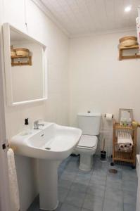 a white bathroom with a sink and a toilet at Florazar 2, 1a línea, piscina. in Cullera