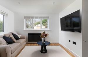 uma sala de estar com um sofá e uma televisão em Lulla Lodge em Lower Boscaswell