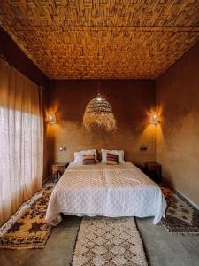 a bedroom with a large bed with a wooden ceiling at Dar Talmoudi in Tagounite