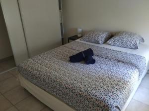 uma cama com um chapéu azul e almofadas em Appartement Saint Raphaël: rez de Jardin, 2 chambres, piscines em Saint-Raphaël