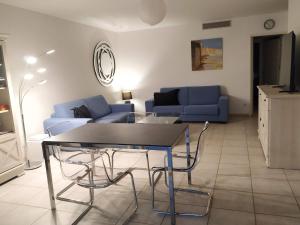 uma sala de estar com uma mesa e um sofá azul em Appartement Saint Raphaël: rez de Jardin, 2 chambres, piscines em Saint-Raphaël