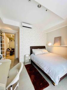 a bedroom with a bed and a table and a desk at [300m to PRJ] Expo Friendly 2BR in Jakarta