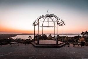 uma grande estrutura metálica com um pôr-do-sol ao fundo em Las Cumbres Hotel em Punta del Este