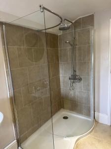 a shower with a glass door in a bathroom at Sugar Plum Cottage in Conisbrough