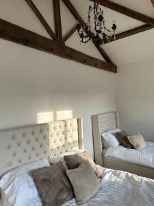 a bedroom with two beds and a chandelier at Sugar Plum Cottage in Conisbrough