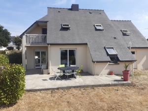 ein Haus mit einem Tisch und Stühlen davor in der Unterkunft Jolie maison dans nature paisible, Côte de Granit Rose proche plage. in Trébeurden