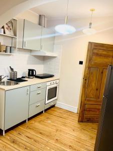 una cucina con mobili bianchi e pavimento in legno di Apartamenty Rynek Staromiejski 24/4 a Toruń Altre 4 foto