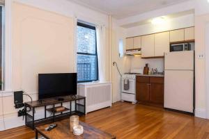 a kitchen with a refrigerator and a table in a room at Spacious Oasis - Hoboken California King Bed! in Hoboken