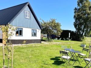 a table and chairs in a yard next to a house at Holiday home Löderup V in Löderup