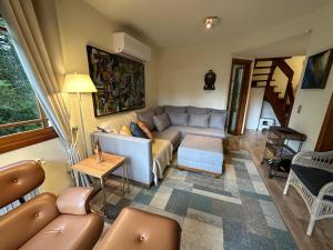 een woonkamer met een bank en een tafel bij Duplex 3 suites com Jacuzzi e Lareira Apto Sattva Plaza in Gramado