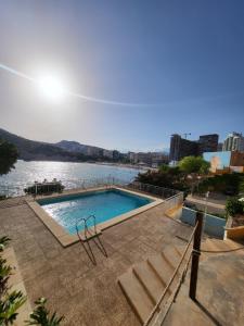 a swimming pool with a view of a body of water at Europa Club Apartment, La Cala de Finestrat, Benidorm, Next to the beach, Ground floor, Air Cond in Benidorm
