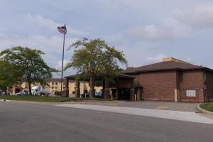 un edificio con una bandera americana en un poste en Baymont by Wyndham Flint Airport North, en Flint