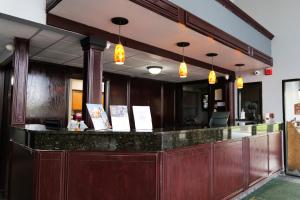 a bar in a restaurant with lights above it at Baymont by Wyndham Flint Airport North in Flint