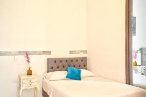 sypialnia z 2 łóżkami i niebieską poduszką w obiekcie Casa Blanca San Antonio Hostal Boutique w mieście Cali