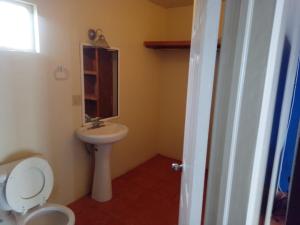 een badkamer met een wit toilet en een wastafel bij Estudios Del Mar km42 in Raulis