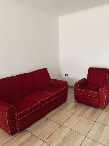 a red couch and a chair in a room at Sarmiento - 1A in Concordia
