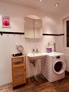 a bathroom with a washing machine and a sink at Schöne Terrassenwohnung zwischen Giessen und Marburg in Staufenberg