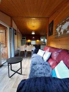 GravièresにあるSud Ardeche joli chalet clim piscine rivière LE CERF Village du serreの赤いソファとテーブルのあるリビングルーム