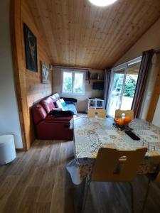 GravièresにあるSud Ardeche joli chalet clim piscine rivière LE CERF Village du serreのテーブルとソファのあるリビングルーム