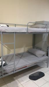 two bunk beds in a room with a rug at Rovers Boys Hostel Dubai Near Gold Souq Metro in Dubai