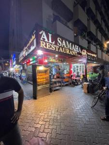 a store with a sign on a street at night at Rovers Boys Hostel Dubai Near Gold Souq Metro in Dubai