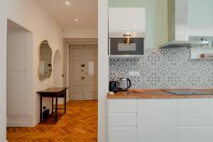 uma cozinha com armários brancos e uma bancada em Casa Settefontane em Trieste