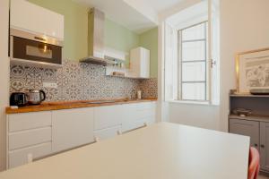 uma cozinha com armários brancos e uma janela em Casa Settefontane em Trieste