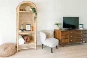 een woonkamer met een spiegel, een stoel en een televisie bij Follow the Leader in Houston