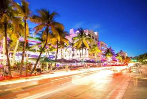 eine Stadtstraße mit Palmen und Autos in der Nacht in der Unterkunft Bungalow King n Queen Bed 5m Wynwood Kitchen in Miami