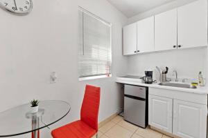 eine Küche mit einem roten Stuhl und einem Glastisch in der Unterkunft Bungalow King n Queen Bed 5m Wynwood Kitchen in Miami