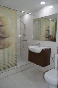 a bathroom with a toilet, sink, and bathtub at The Golden Truly Hotel & Casino in Paramaribo