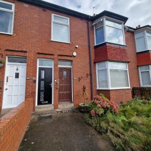 a red brick house with white doors and windows at Double room in Heaton in Heaton