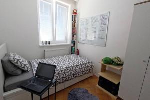 um quarto com uma cama com um computador portátil em Vienna: Cozy 2-Room Apt. (U3 - Schweglerstrasse) em Viena