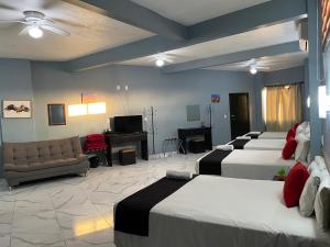 een hotelkamer met 3 bedden en een bank bij Guadalajara Express Tonala in Guadalajara