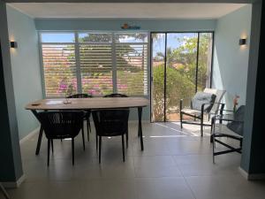 uma sala de jantar com mesa e cadeiras e uma janela em Kas di BaMi A-186 op Seru Coral Resort - Ruim appartement met groot zwembad en tropische tuin em Willemstad