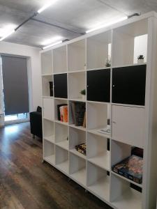 a large white book shelf in a room at Erdvi studija Spacious studio apartment Self check in in Vilnius