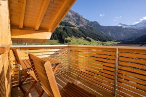 a balcony with two chairs and a view of mountains at Chuenislodge2- zwei Balkone, gemütlicher Kamin, top Aussicht in Adelboden