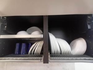 a shelf filled with plates and bowls and dishes at Erdvi studija Spacious studio apartment Self check in in Vilnius