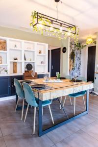 uma sala de jantar com uma grande mesa de madeira e cadeiras em New Villa Oasis- Clim- Piscine privé- Cosy- famille TOP PROS SERVICESCONCIERGERIE em Saint-Gély-du-Fesc