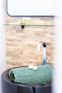 a bathroom sink with a green towel on it at New Villa Oasis- Clim- Piscine privé- Cosy- famille TOP PROS SERVICESCONCIERGERIE in Saint-Gély-du-Fesc